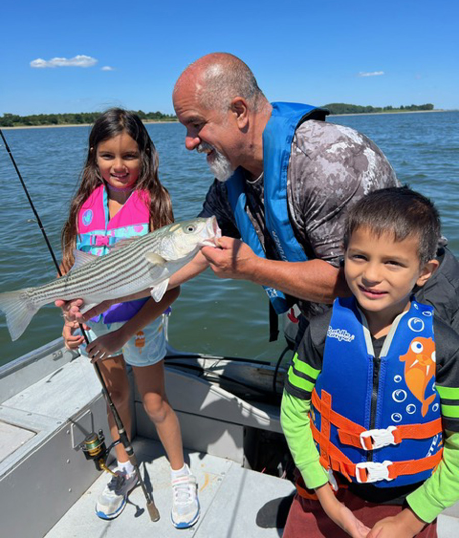 Amelia, Eli, and grandpa Paul with striped bass